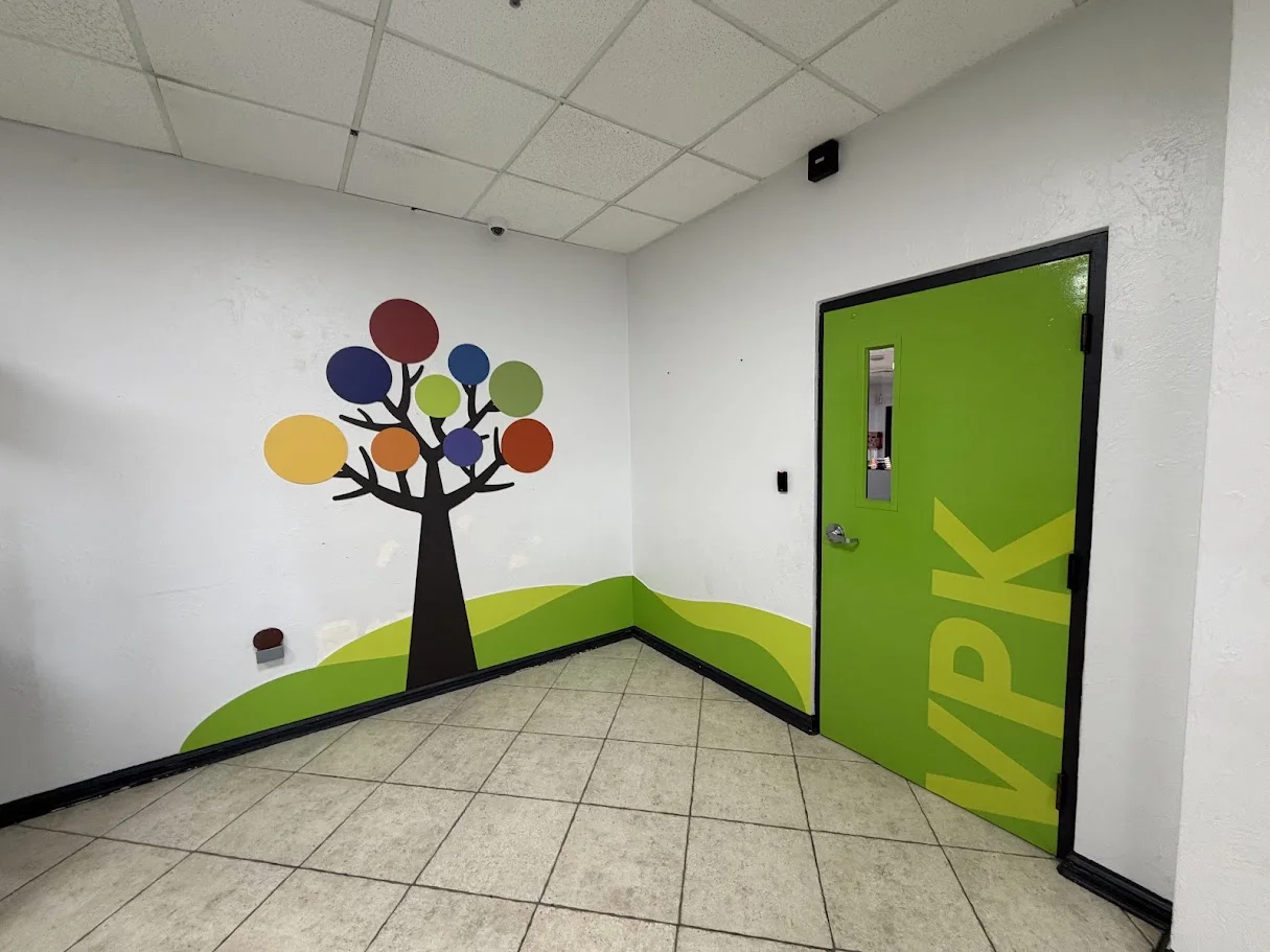 FCCA VPK classroom entrance with colorful tree mural and green VPK door
